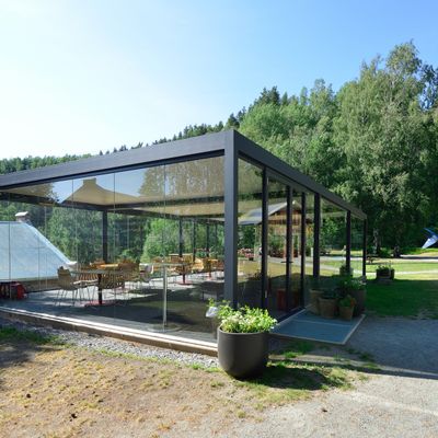 Glassinnrammet pergola i grønne omgivelser